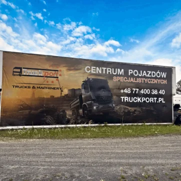 Baner reklamowy z nadrukiem na kontenerze – duży baner firmowy z logo i telefonem, realizacja DrukXpert